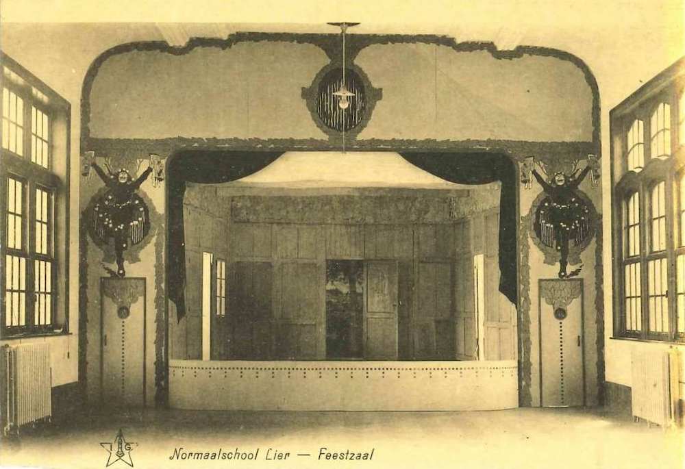 De feestzaal (het huidige Lectoraat) d.d. 1926 met het oude theaterpodium, versierd met een kleurrijk uitgedoste harlekijn, geschilderd door J.R. Coulon (1887 – 1977), leerkracht Nederlands en Engels van 1919 tot 1947.